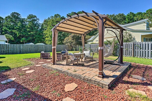 A covered patio with a pergola, outdoor seating, and a fire pit. - Cozy Wilmington Bungalow ~ 6 Mi to Beaches! (Wilmington)