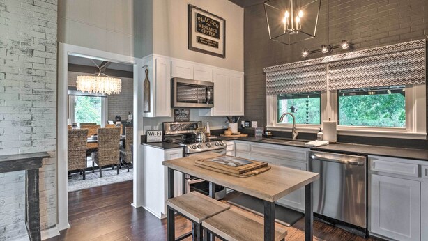 A modern kitchen with a central island, stainless steel appliances, and a view of the outdoors. - Chic Family-friendly Home With Outdoor Oasis! (Lampasas)