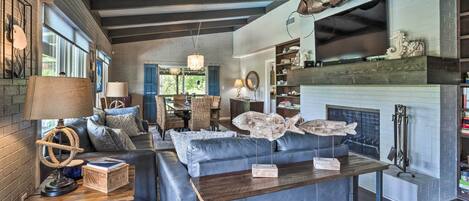 A modern living room with a fireplace, leather sofa, and wooden coffee table.