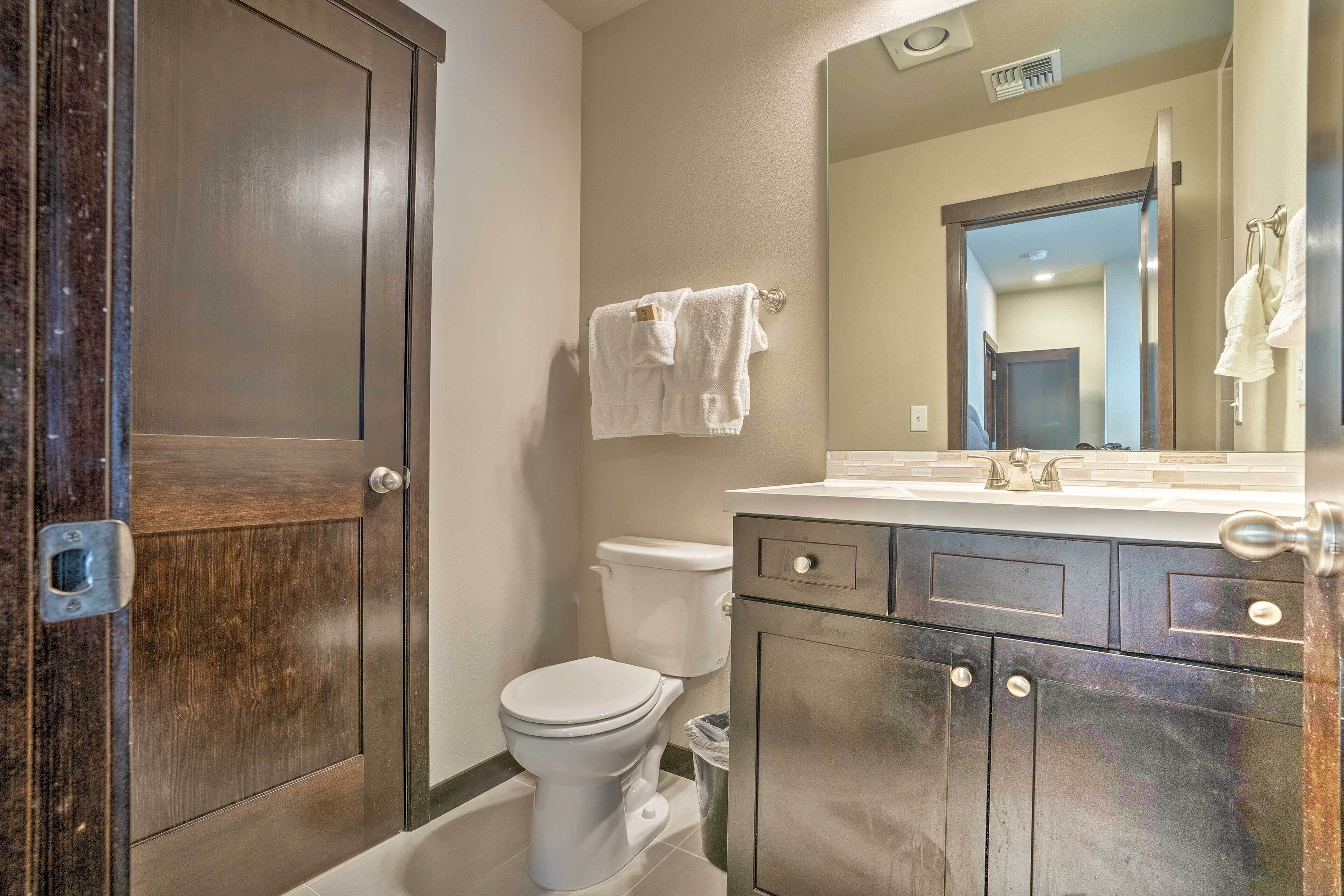 Une salle de bain avec des toilettes, un lavabo et un miroir.