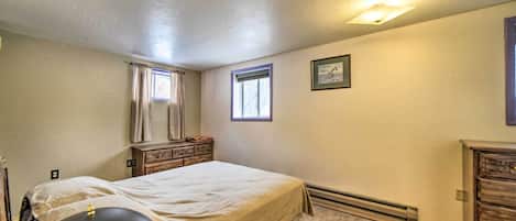 A bedroom with a bed, a dresser, a chair, a window, and a picture on the wall.