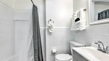 Ein modernes Badezimmer mit einer Badewanne, Toilette und Waschbecken.