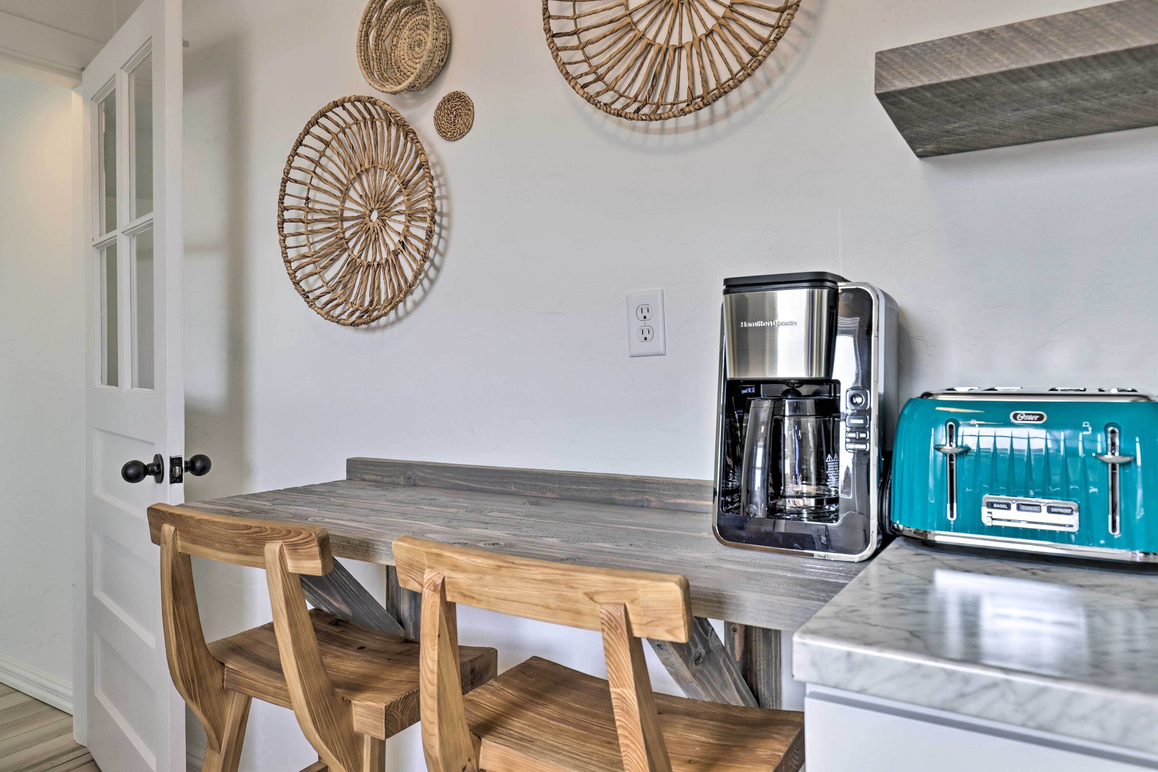 A kitchen with a wooden table, a coffee maker, and a vintage toaster.