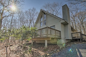 A two-story house with a large front window, a chimney, and a deck. - Cozy Wintergreen Cabin Near Mountain Inn & Slopes! (Nellysford)