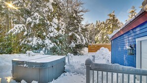 A snow-covered outdoor area with a hot tub, a wooden deck, and a blue building with a lantern. - Ultimate Mountain Home w/ Hot Tub! (Tannersville)