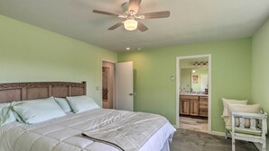 A bedroom with a bed, a ceiling fan, and a door leading to a bathroom. - Picturesque Palisade Home: Mt Garfield Views! (Palisade)