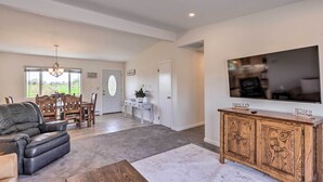 A spacious living room with a leather sofa, a wooden coffee table, and a TV on a wooden cabinet. - Picturesque Palisade Home: Mt Garfield Views! (Palisade)