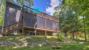 A two-story deck with a wooden railing, a blue umbrella, and a view of a wooded area. - Massanutten Family Retreat: Ski, Golf, & Hike! (McGaheysville)