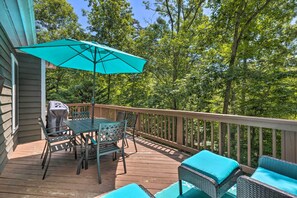 A wooden deck with outdoor furniture, including a table and chairs, and a covered grill area. - Massanutten Family Retreat: Ski, Golf, & Hike! (McGaheysville)