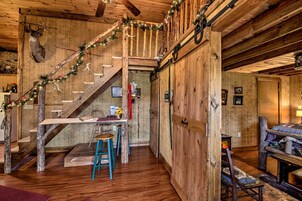 Un interior rústico con una escalera de madera, un comedor y una zona de estar acogedora.