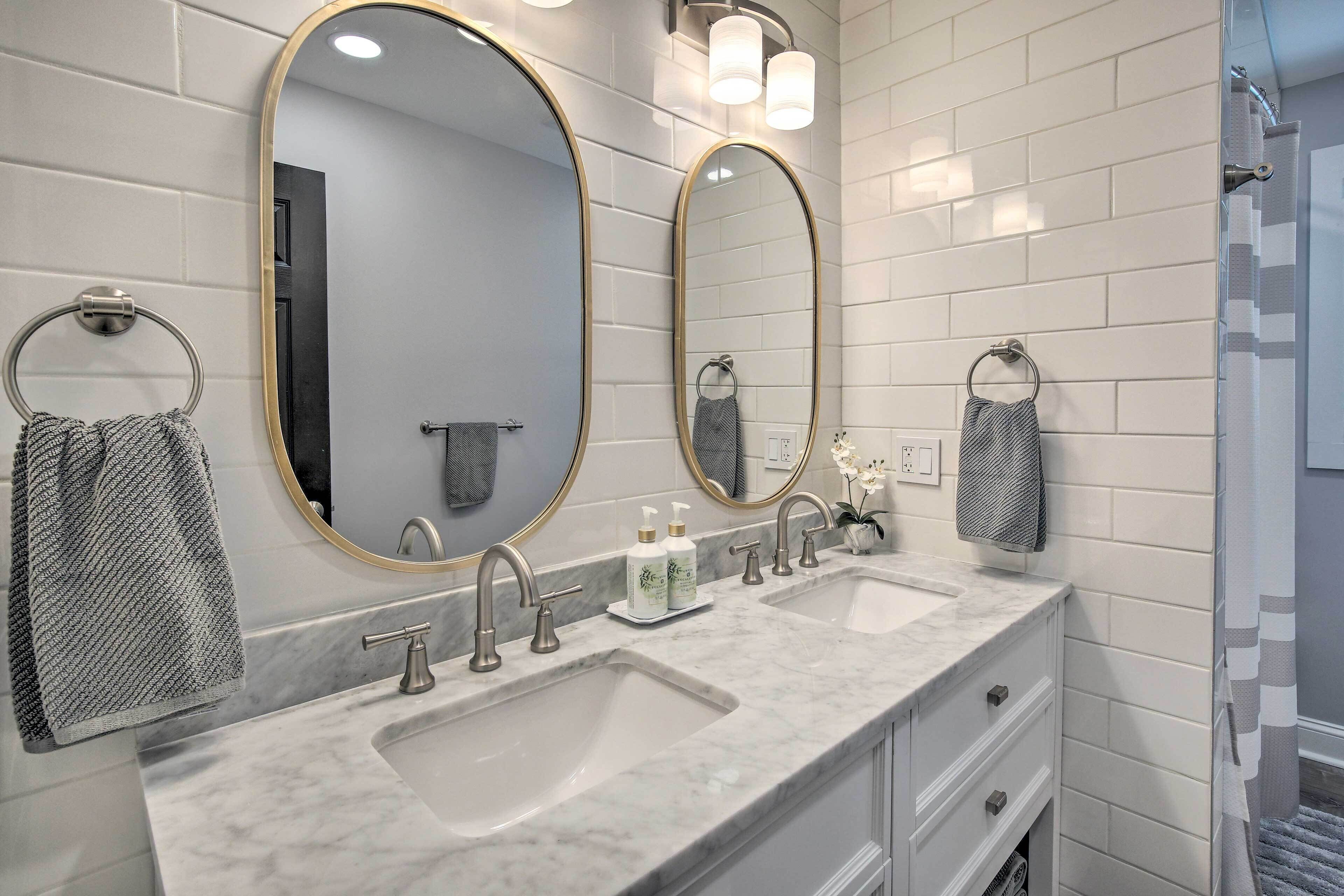 A bathroom with two sinks, a large mirror, and a towel rack.