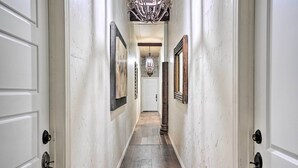 A hallway with white walls, a wooden floor, and a chandelier. - Ideally Located Vacation Rental Studio in Laredo! (Laredo)