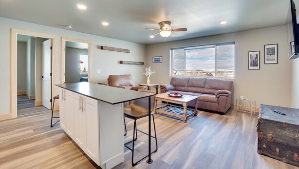 A modern living room with a sofa, a coffee table, and a dining area. - Saratoga Retreat ~ 3 Mi to Saratoga Lake! (Saratoga)