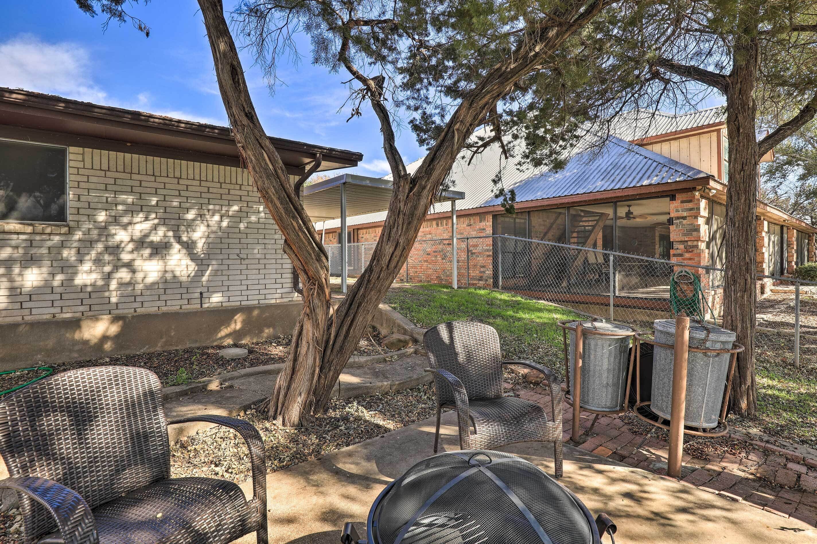 A patio area with wicker chairs, a grill, and a covered outdoor space.