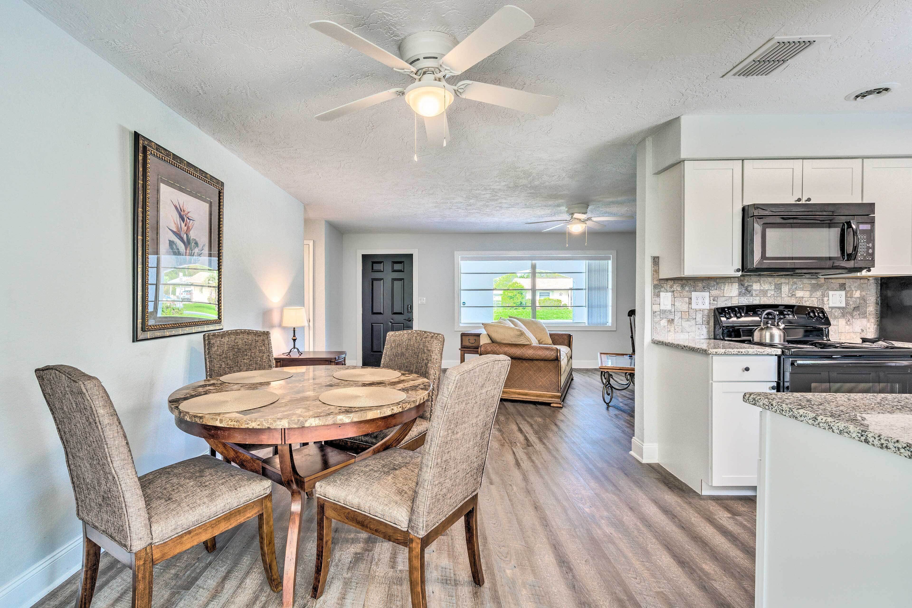 A spacious kitchen with a microwave, stove, and granite countertop.