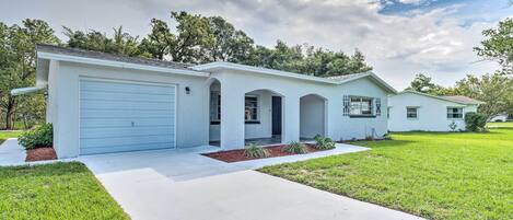A single-story house with a garage, a covered porch, and a well-maintained lawn.