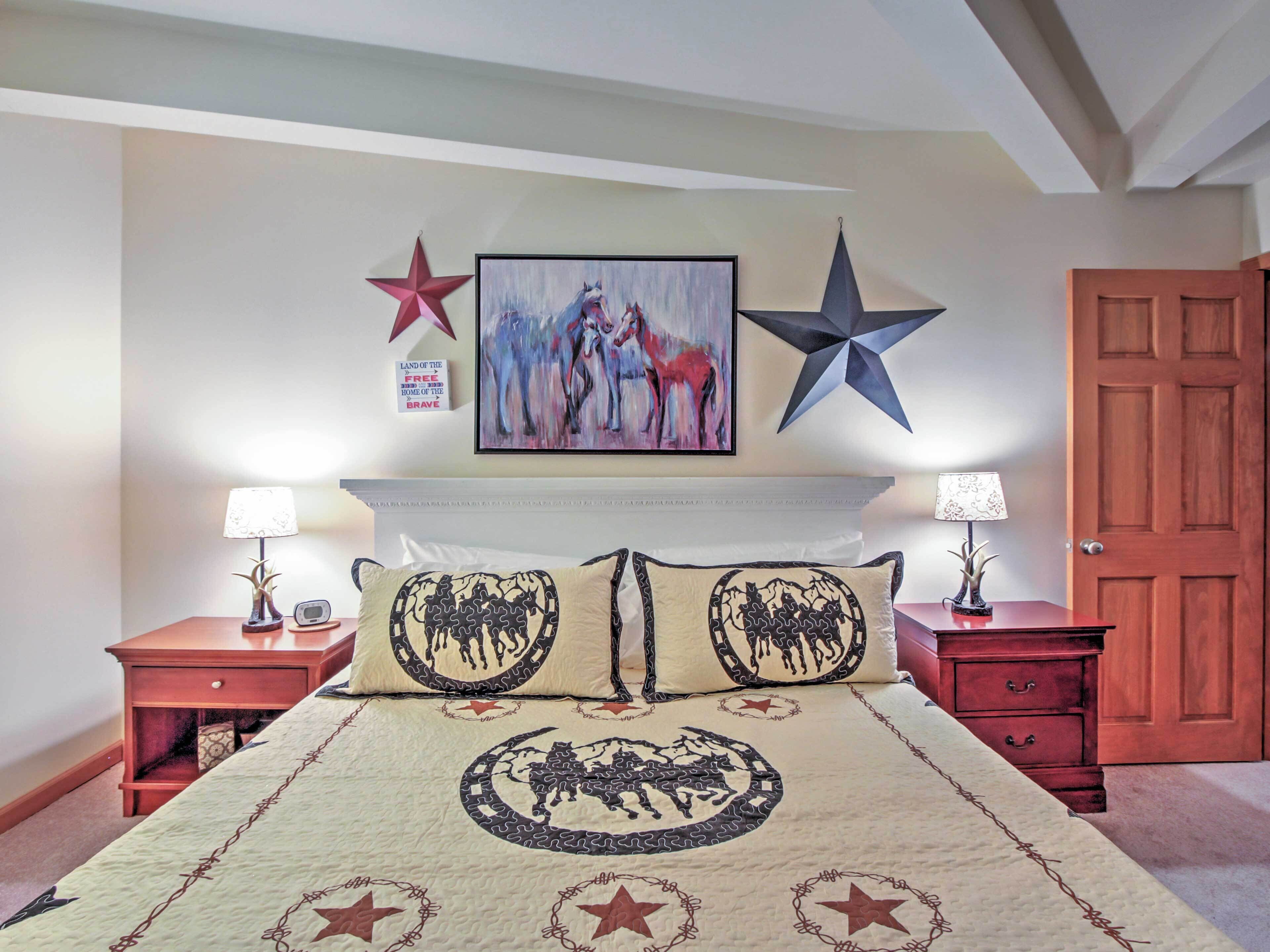 Une chambre à coucher comprenant un lit, deux tables de chevet, une commode, un tableau accroché au mur et une décoration en forme d’étoile.