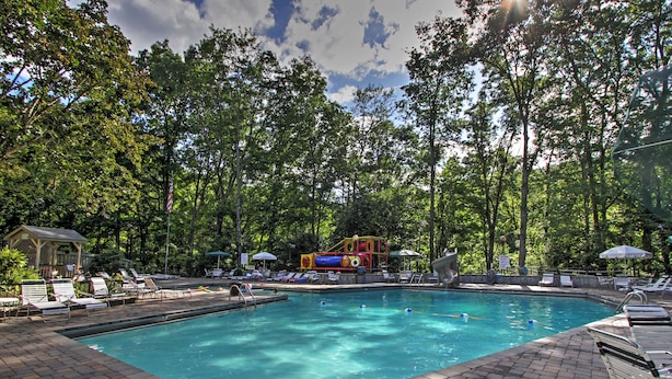 A swimming pool with a water slide and lounge chairs. - Unique Gatlinburg Cabin: Decks, Hot Tub, Fire Pit (Gatlinburg)