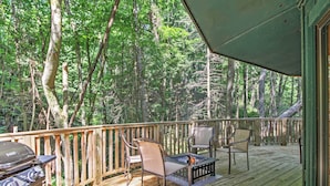 A wooden deck with outdoor furniture and a grill. - Unique Gatlinburg Cabin: Decks, Hot Tub, Fire Pit (Gatlinburg)