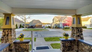 A covered entrance with stone pillars, a driveway, and houses in the background. - Indiana Vacation Rental - Walk to Syracuse Lake! (Syracuse)