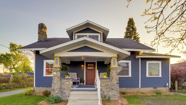 A two-story house with a stone chimney, a front porch with steps, and a front door. - Indiana Vacation Rental - Walk to Syracuse Lake! (Syracuse)