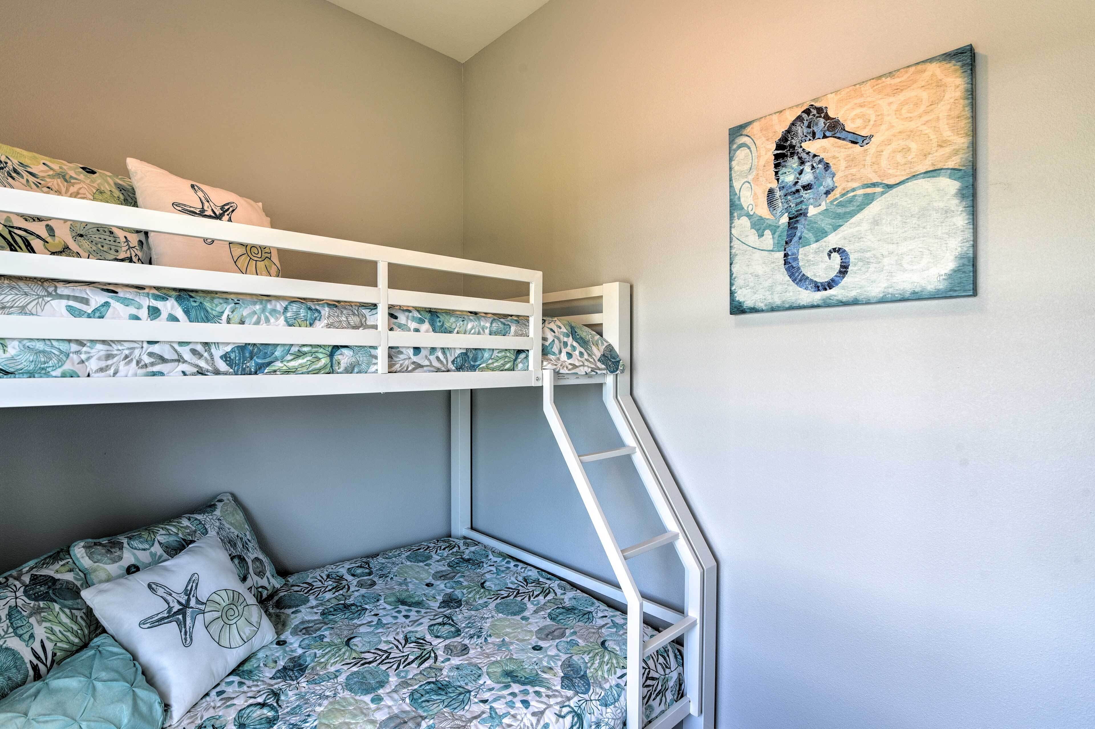 A bunk bed with a ladder, a seahorse painting, and floral-patterned bedding.