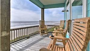 A wooden deck with two Adirondack chairs facing a beach view. - Crystal Tides - Stunning Home W/oceanfront Views (Port Bolivar)
