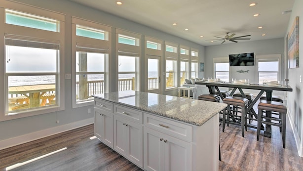 A spacious kitchen with large windows, a central island, and a view of the ocean. - Crystal Tides - Stunning Home W/oceanfront Views (Port Bolivar)