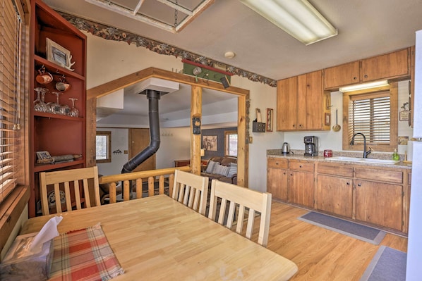 A cozy kitchen with wooden cabinets, a dining table, and a fireplace.