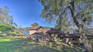 A two-story house with a sloped roof, a covered porch, and a view of a lake. - Waterfront Clearlake Retreat w/ Dock & Kayaks (Clearlake)