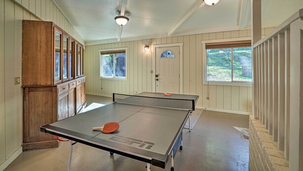 A room with a ping pong table, wooden cabinets, and a door with a window. - Waterfront Clearlake Retreat w/ Dock & Kayaks (Clearlake)