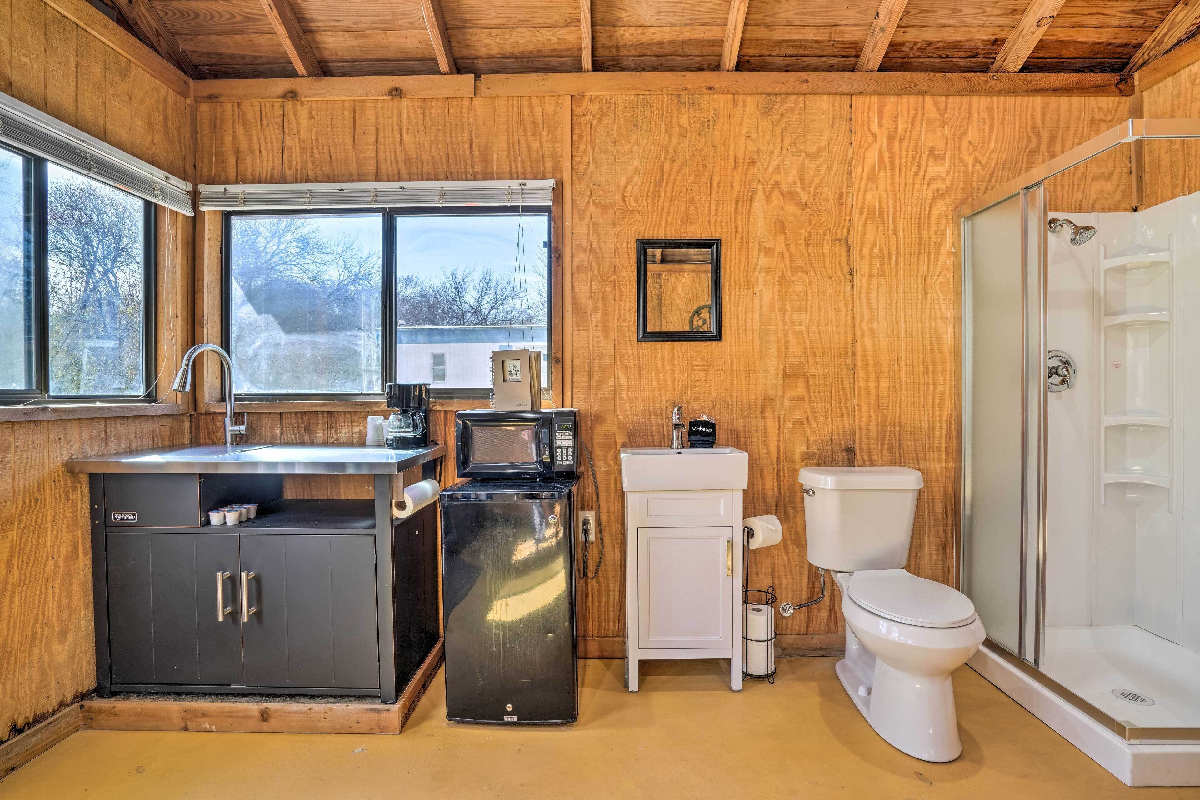 A compact bathroom with a sink, toilet, and shower.