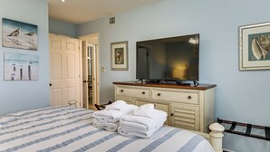 A bedroom with a bed, a dresser, a television, and artwork on the walls. - Beach & Pool Access: Hilton Head Resort Condo (Hilton Head Island)