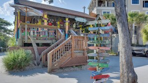 A colorful building with a wooden staircase and a signpost with multiple destination signs. - Beach & Pool Access: Hilton Head Resort Condo (Hilton Head Island)