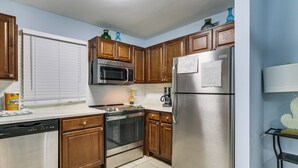 A kitchen with wooden cabinets, stainless steel appliances, a dishwasher, and a coffee maker. - Beach & Pool Access: Hilton Head Resort Condo (Hilton Head Island)