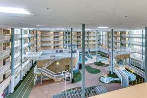 Et hotel med en fleretages atriumgård, altaner, en central gårdhave og en swimmingpool.