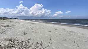 Ein Strand mit blauem Himmel und ruhigem Meer.