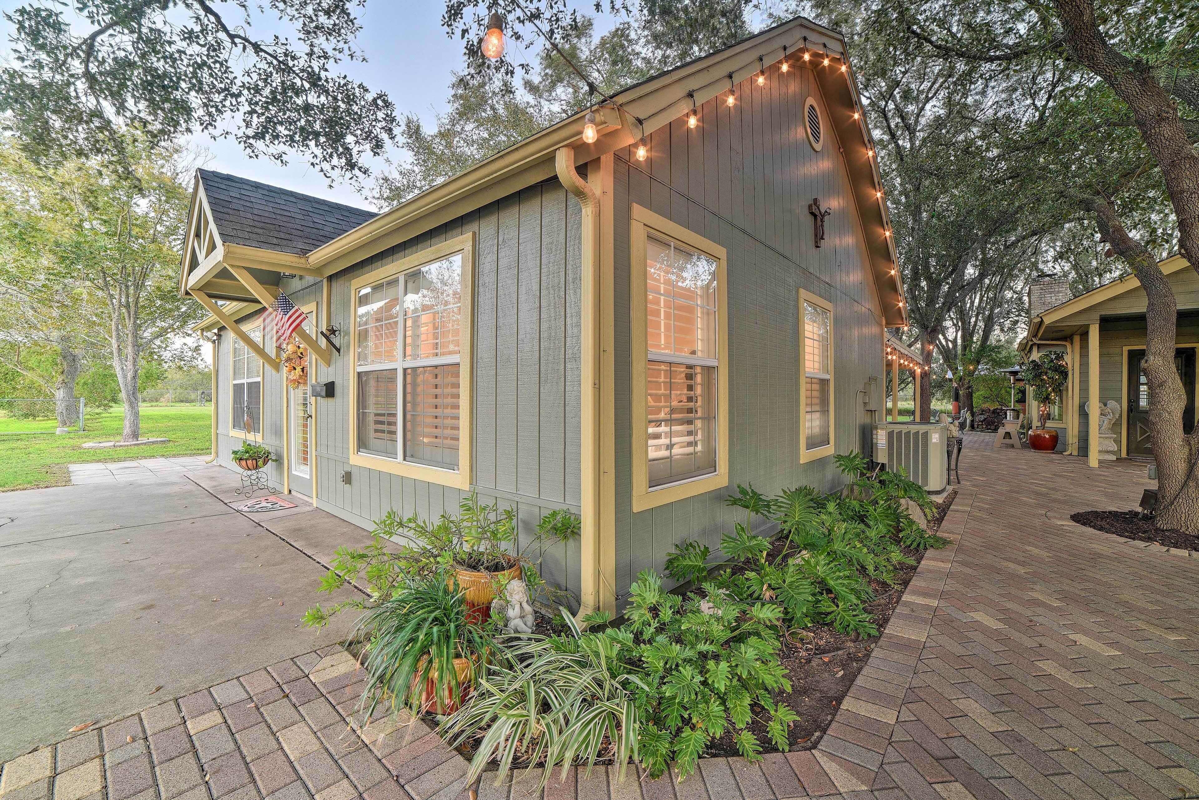 A house with a porch, a small garden, and string lights.