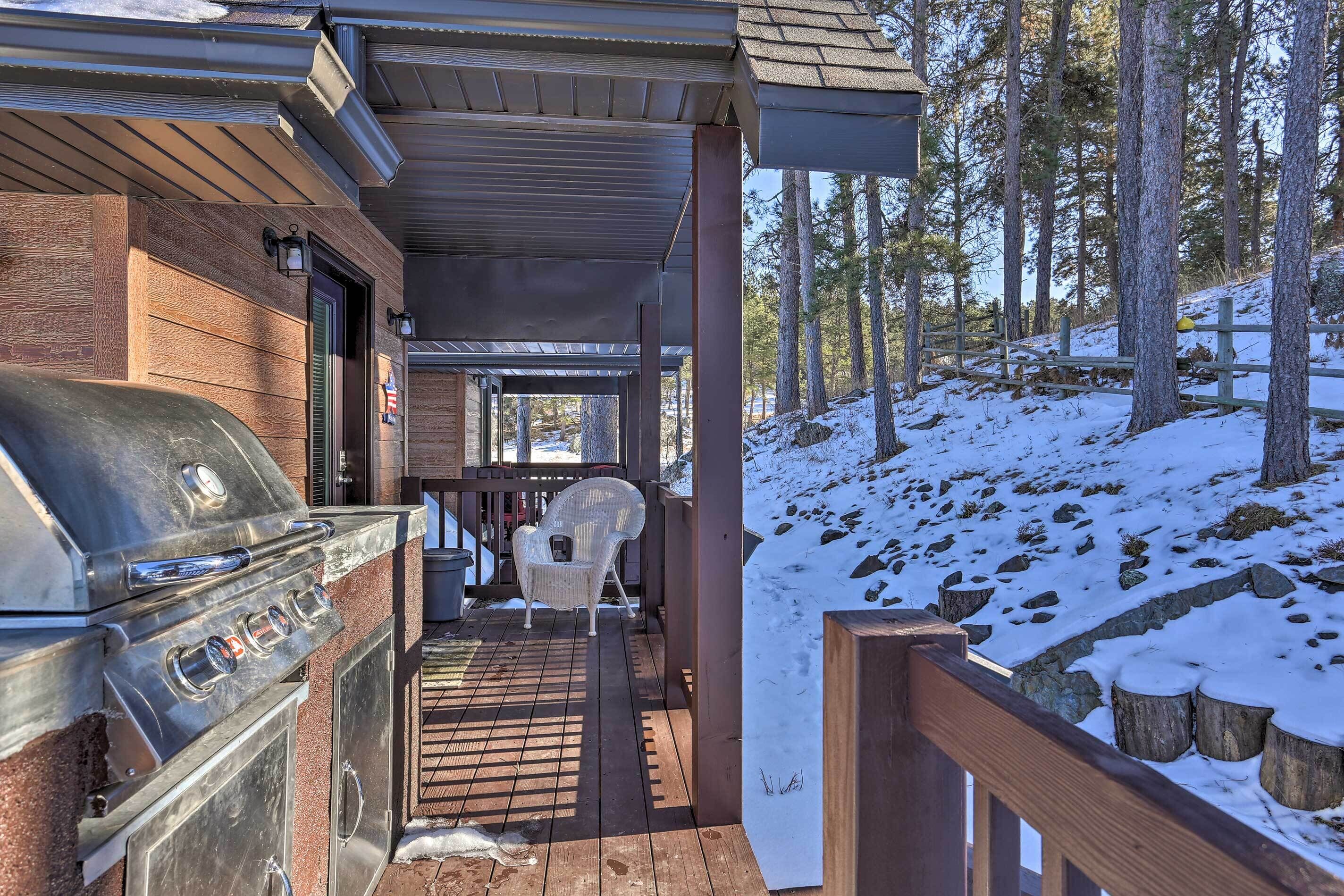 Un espace extérieur abrité comprenant un barbecue, une chaise et une terrasse en bois.