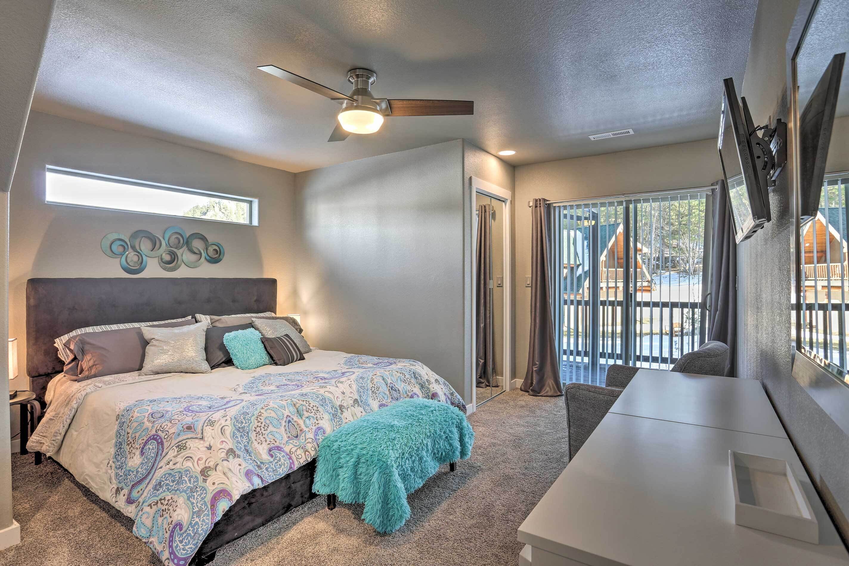 A bedroom with a bed, a ceiling fan, a window, and a view of the outside.