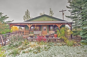 A rustic cabin with a porch, wooden benches, and potted plants. - Bozeman Cottage w/ Mountain Views < 6 Mi to Dtwn! (Bozeman)