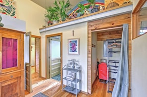 A hallway with wooden flooring, a metal rack with a basket, and a red bag hanging on a rack. - Bozeman Cottage w/ Mountain Views < 6 Mi to Dtwn! (Bozeman)