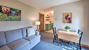 A living room with a sofa, a dining table with chairs, and two paintings on the walls. - Private Mccall Apartment w/ Mountain View! (McCall)
