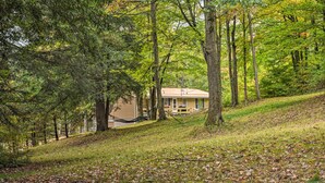 A house surrounded by trees on a grassy slope. - Great Valley Home w/ On-site Pond, 7 Mi to Skiing! (Great Valley)