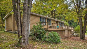 A single-story house with a porch, surrounded by trees and fallen leaves. - Great Valley Home w/ On-site Pond, 7 Mi to Skiing! (Great Valley)