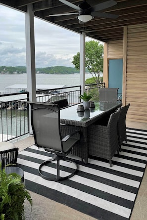 A balcony with a table and chairs, a view of the water, and a railing. - 2 Pools, Boat Slip: Waterfront Condo in Lake Ozark (Lake Ozark)