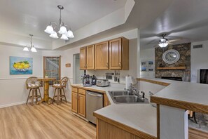 A modern kitchen with wooden cabinets, a built-in dishwasher, and a stone backsplash. - Blue Ridge Mtn Views: Condo w/ Furnished Balcony (Burnsville)