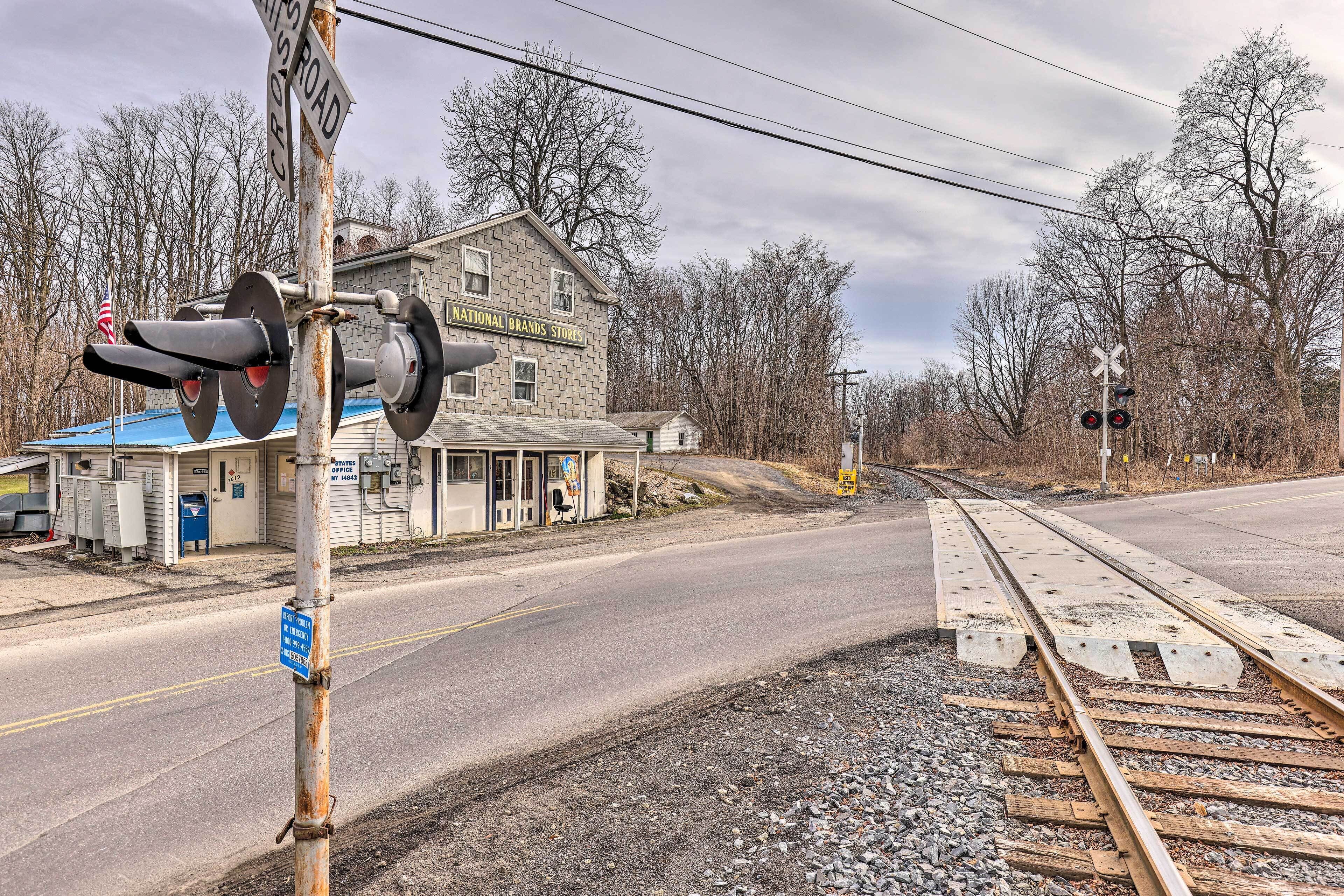 A railroad crossing with a building labeled "NATIONAL BRANDS STORES" in the background.