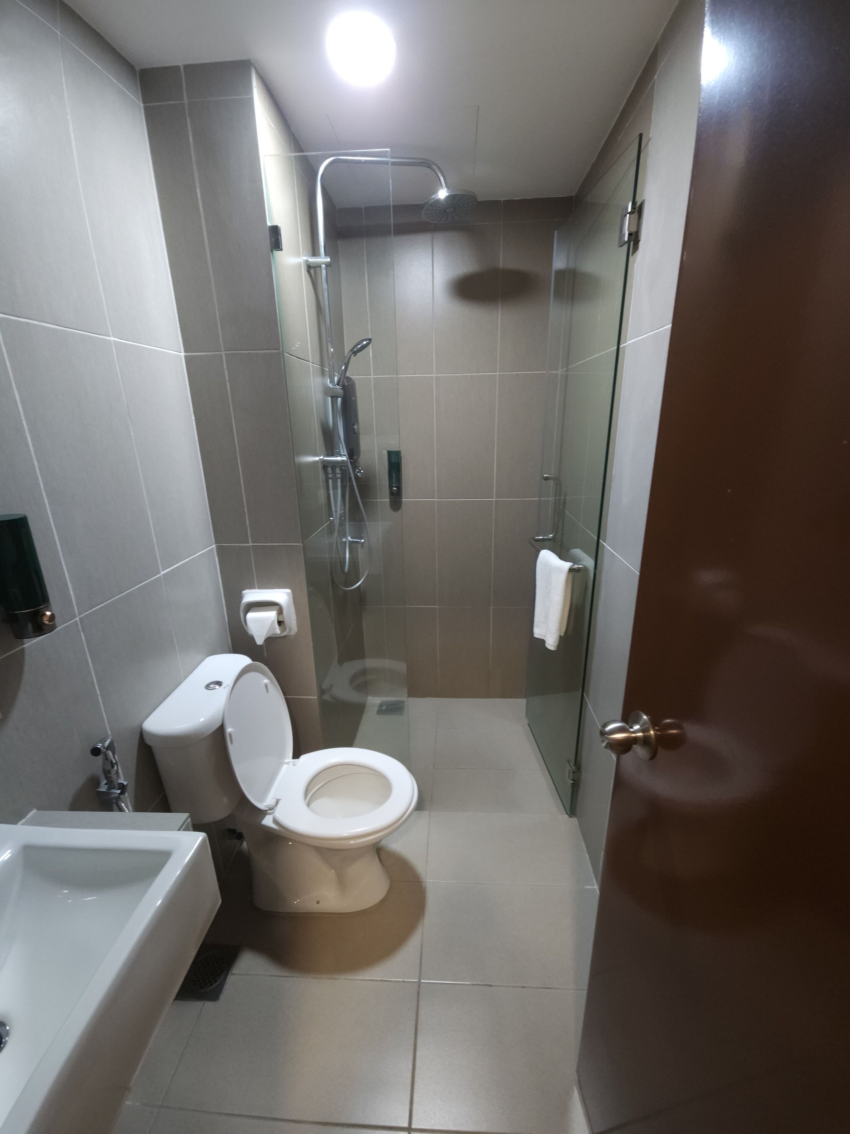 A modern bathroom with a toilet, shower, and bathtub.