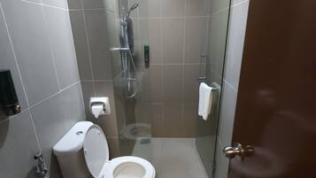 A modern bathroom with a toilet, shower, and bathtub.